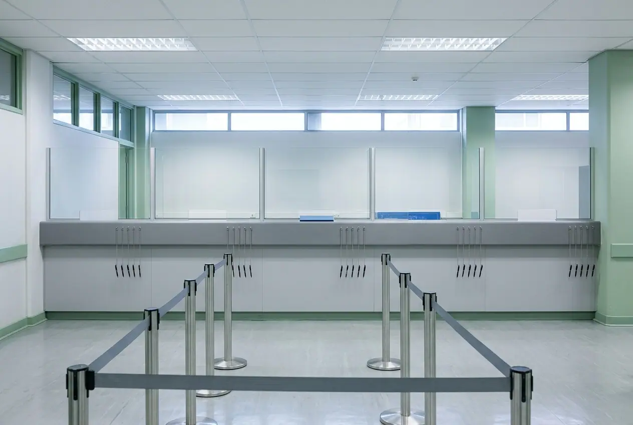 The public lodgement counter of a deeds office, empty of people: a long counter with numbered service positions, glass screens and a queue barrier in the foreground.